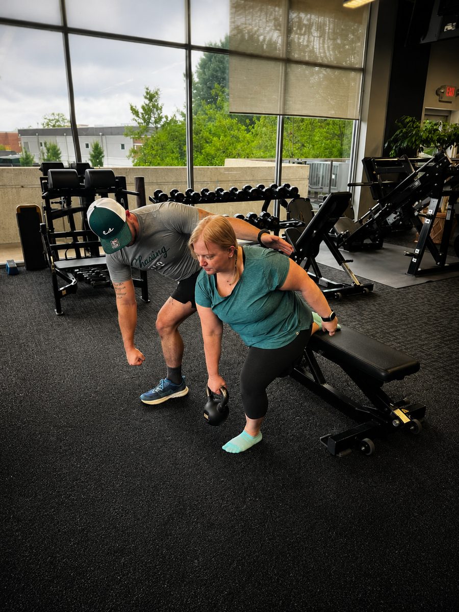Brian coaching a client through a single-arm kettlebell hip hinge